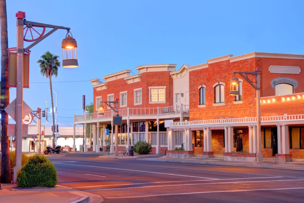 Charming Downtown Main Street in Gilbert, Arizona at dusk with boutique shops and outdoor lighting.