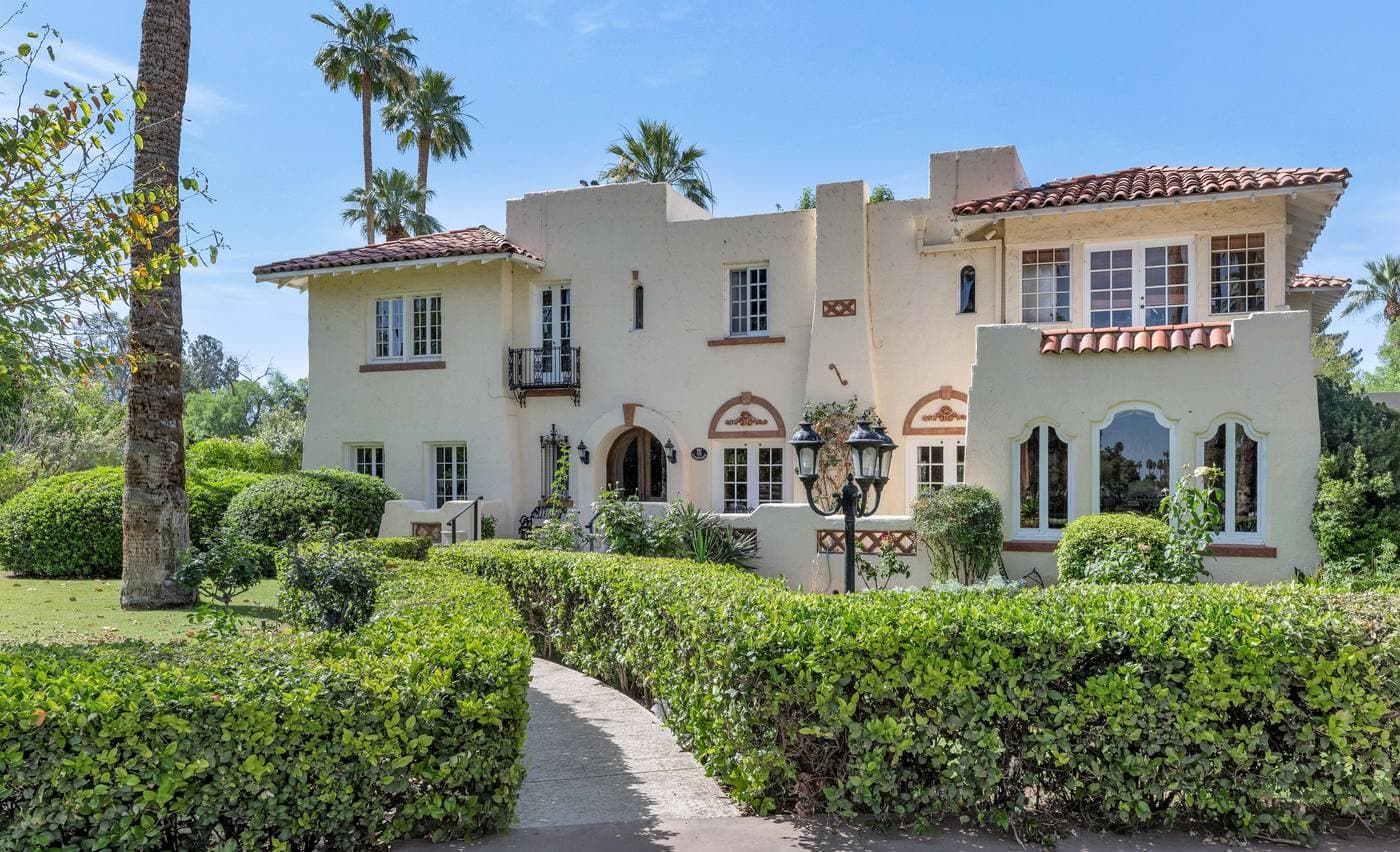 161 E Country Club Drive Phoenix — exterior view of 1928 Spanish estate with mature landscaping and wrought iron fencing