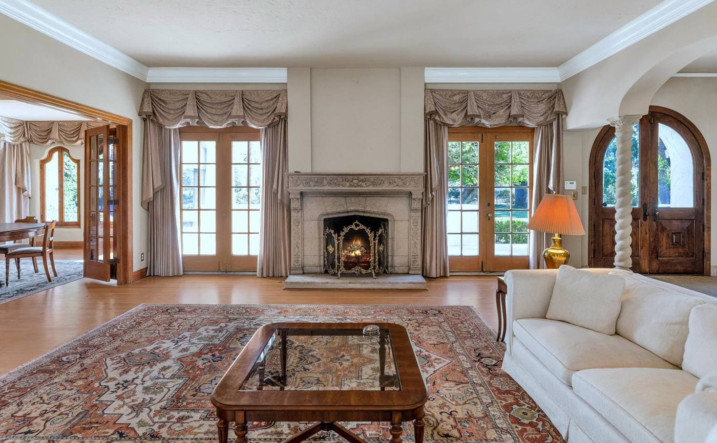 161 E Country Club Drive Phoenix — 1928 Spanish estate living room with carved stone fireplace and French doors